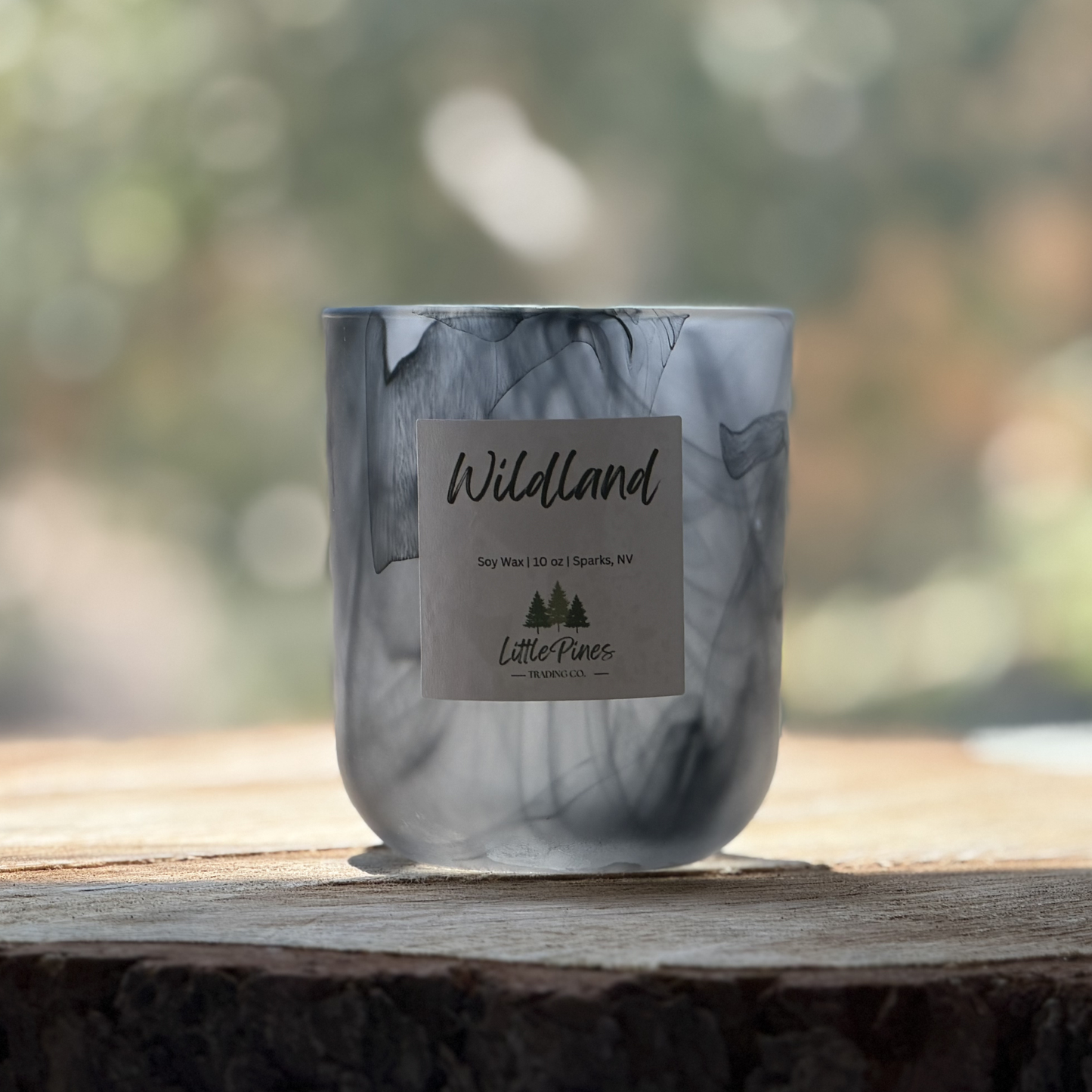 Marble-patterned candle with a label on a wooden surface